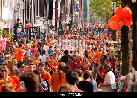 Kingsday la fête du Roi des rois journée à Amsterdam. Affluence sur le côté de la Canal Prinsengracht. La plupart habillés en orange. Banque D'Images