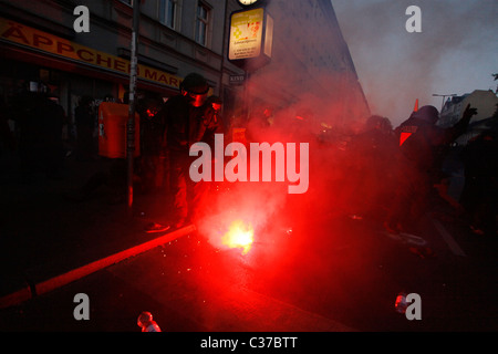 Des manifestants et des policiers se tiennent autour d'une éruption rouge, alors que de violents affrontements entre les militants de l'extrême gauche et la police d'Antifa ont eu lieu lors d'un rassemblement de protestation lors de la Journée internationale des travailleurs, également connue sous le nom de Fête du travail ou de mai, le 01 mai dans le quartier de Kreuzberg à Berlin en Allemagne Banque D'Images