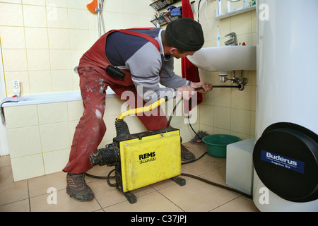 Un plombier l'élimination d'un drain obstrué Banque D'Images