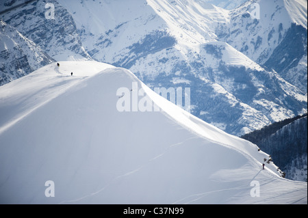 Un groupe de skieurs et surfeurs marchant le long d'une crête enneigée à Argentera (Italie). Banque D'Images