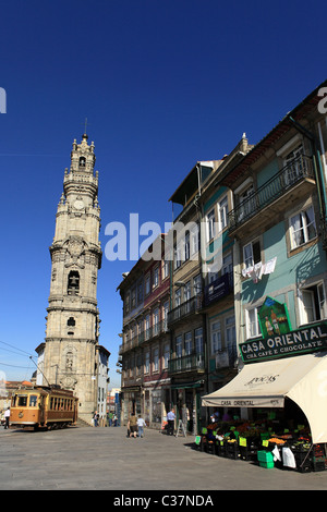 Un tram s'exécute par l'Église et la Tour des Clercs et la Casa boutique orientale à Porto, Portugal. Banque D'Images