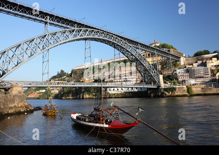 Rabelo bateaux flottent sur le fleuve Douro sous le Roi Luis je pont à Porto, Portugal. Banque D'Images