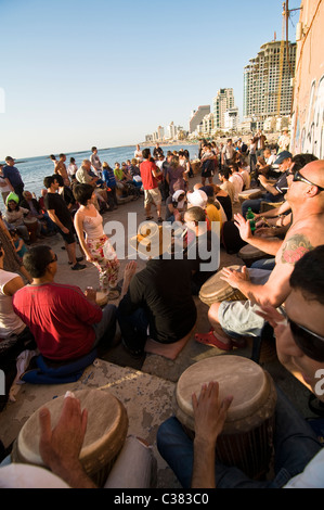 Vendredi après-midi drumming session lors de l'heures du coucher du soleil à le Dolfinarium beach à Tel Aviv. Banque D'Images