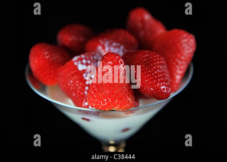 Crème de fraise et Wimbledon dans un verre contre fond blackk Banque D'Images