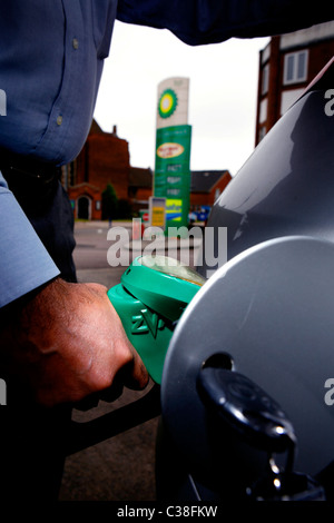 Un homme plein sa voiture à une station-service BP. Banque D'Images