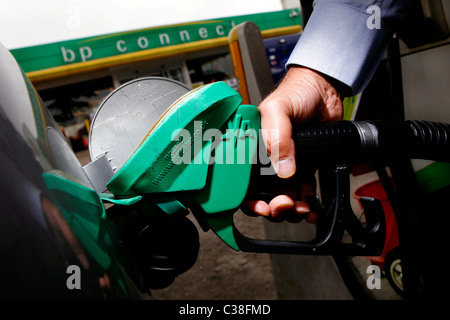 Un homme plein sa voiture à une station-service BP. Banque D'Images