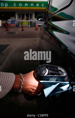 Un chauffeur de taxi son ravitaillement en cabine à une station-service BP à Londres. Banque D'Images