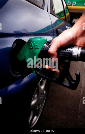 Un homme plein sa voiture à une station-service BP. Banque D'Images