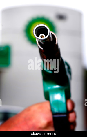 Un homme à l'aide d'une pompe à essence à une station-service BP, avec le logo de BP dans l'arrière-plan. Banque D'Images