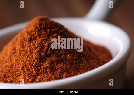 Dans le épices paprika une cuillère en céramique blanc avec Banque D'Images