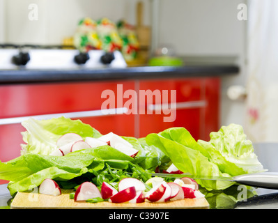 Certains la laitue, les oignons verts et de radis prêt à les couper pour une salade saine sur la table Banque D'Images