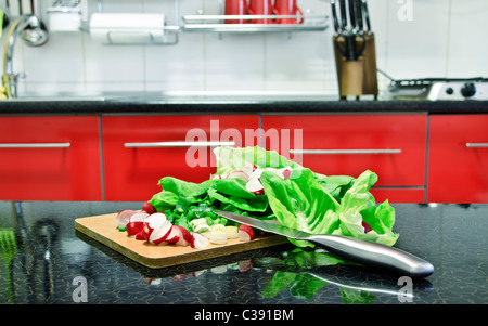 Certains la laitue, les oignons verts et de radis prêt à les couper pour une salade saine. Banque D'Images