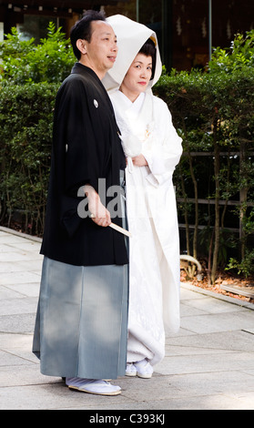 Mariée et le marié qui pose pour photos portant des kimonos traditionnels dans le sanctuaire de Meiji, Tokyo, Japon Banque D'Images