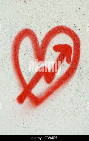 Coeur rouge peint sur mur blanc et la flèche de Cupidon. Banque D'Images