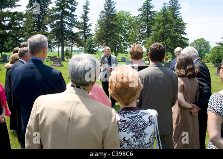 Ministre d'effectuer le renvoi à un enterrement au cimetière avant d'amis et de la famille au cimetière. St James Minnesota MN USA Banque D'Images