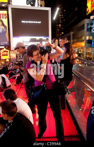 Photographe enthousiaste à Times Square la nuit, New York USA Banque D'Images
