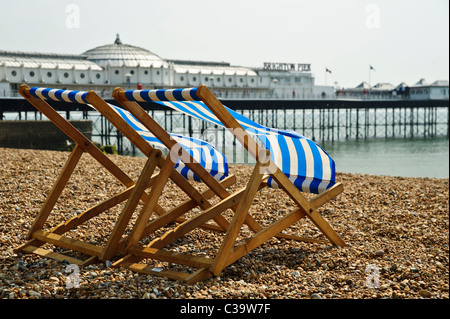 BRIGHTON, UK 29/04/2011. Deux deckhairs (bande bleue en tissu) sur la plage de Brighton en face de la jetée. Banque D'Images