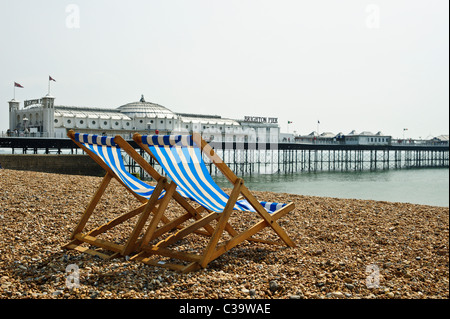 BRIGHTON, UK 29/04/2011. Deux deckhairs (bande bleue en tissu) sur la plage de Brighton en face de la jetée. Banque D'Images