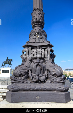 Détail d'un lampadaire en fonte sur le Pont Neuf, Paris, avec un statut d'Henry IV dans l'arrière-plan Banque D'Images