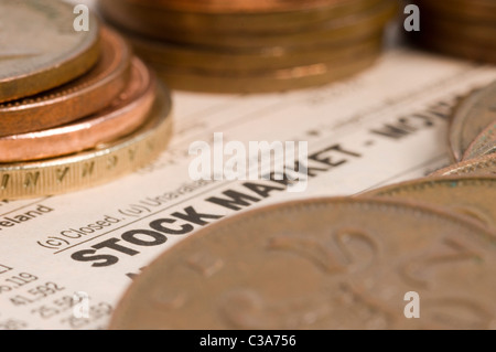 Pièces diverses sur la photo en haut d'une page de journal des marchés boursiers. Banque D'Images