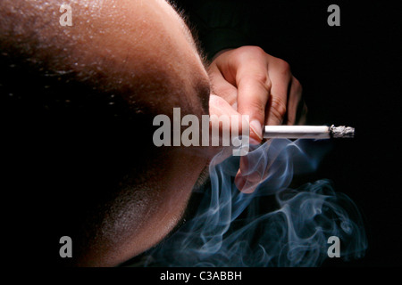 Un homme fume une cigarette vu de dessus. Banque D'Images