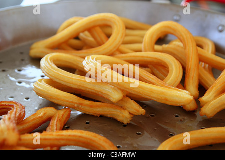 Churros frit dans de l'huile végétale alimentaire graisse malsaine Banque D'Images