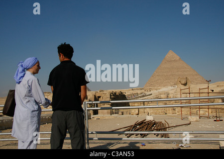 Un couple de touristes en face de l'Khafré Khéphren pyramide de Gizeh, Le Caire, Égypte. Banque D'Images