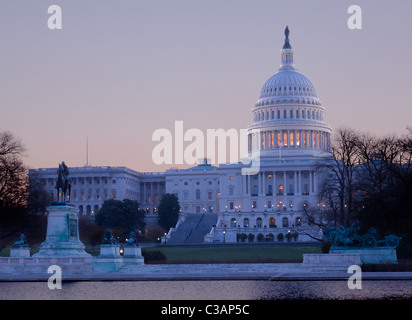 Aube du ciel lumineux derrière le dôme lumineux du Capitole à Washington DC avec la piscine et ses statues Banque D'Images