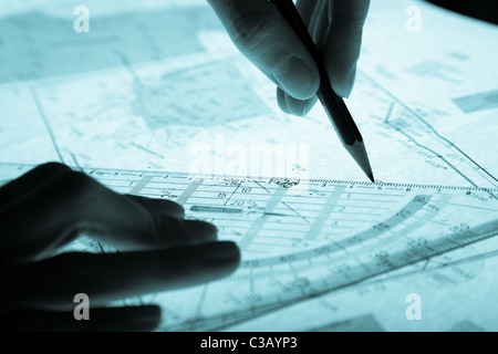 Plan du géomètre et les mains avec un crayon, bleu monochromatique Banque D'Images