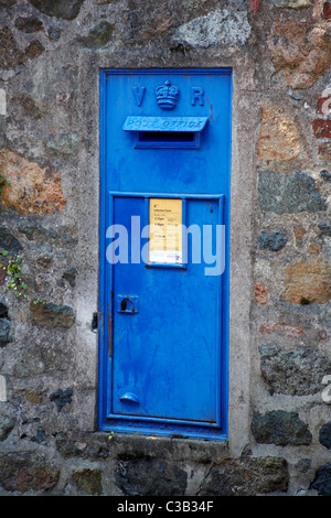 Bureau de poste aux lettres VR bleu situé dans mur de pierre en Port St Pierre en Avril Banque D'Images