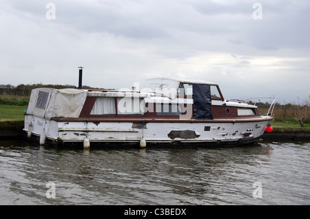Très négligé cruiser amarré près de Potter Heigham sur la rivière Thurne, Norfolk Broads, East Anglia, Angleterre. Banque D'Images