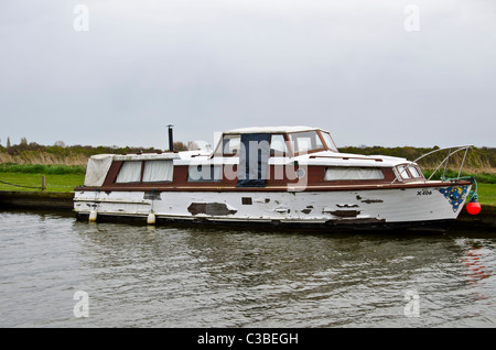 Très négligé cruiser amarré près de Potter Heigham sur la rivière Thurne, Norfolk Broads, East Anglia, Angleterre. Banque D'Images