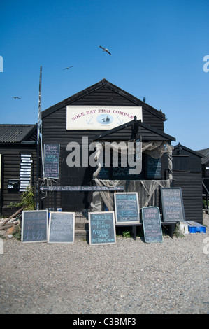 Seul Bay Fish Company boutique de poissons au port de Southwold Suffolk Angleterre Royaume-uni. Cabane en bois avec un grand nombre de panneaux pour la vente du poisson de la publicité. Banque D'Images