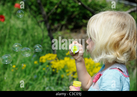 Stock photo d'une fille de cinq ans faisant des bulles. Banque D'Images