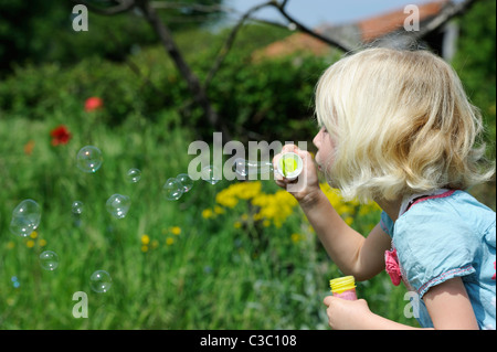 Stock photo d'une fille de cinq ans faisant des bulles. Banque D'Images