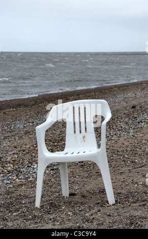 Une chaise blanche en plastique sur la berge à Musselburgh près d'Édimbourg, Écosse, Royaume-Uni. Banque D'Images