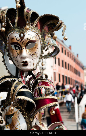 Les masques de Mardi Gras sur l'écran près de la Piazza San Marco sur la Riva degli Schiavoni à Venise, Italie Banque D'Images