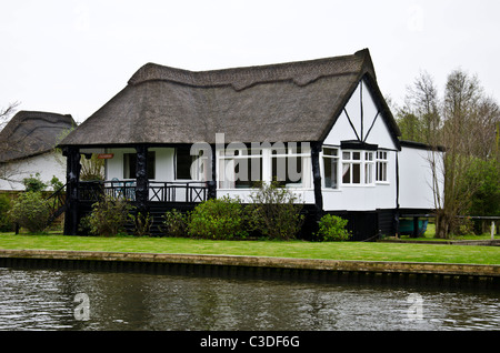 Thatched cottage sur la rivière Bure près de Wroxham sur les Norfolk Broads, East Anglia, Angleterre. Banque D'Images