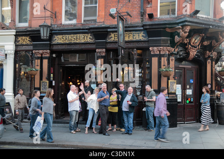 La foule des buveurs le photographe toast à l'extérieur du pub de Salisbury, St Martin's Lane, London, WC2, UK Banque D'Images