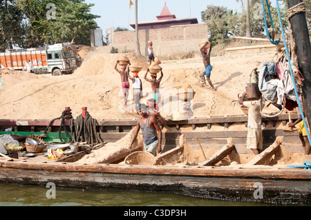 Le Diara, Bihar, en Inde en mars 2011. Sable de travailleurs à partir d'un bateau .Le sable sont recueillies à partir d'îles dans le Gange. Banque D'Images