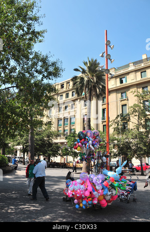 Ciel bleu Voir l'hélium de ballons pour enfants sur un support en dessous des arbres, Plaza de Armas, Santiago, Chili Banque D'Images