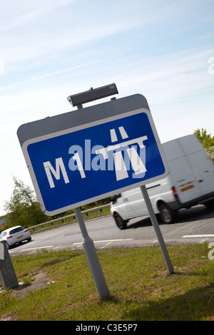 Signe de l'autoroute M1 en Angleterre. Journée ensoleillée avec ciel bleu. White van et voiture voyage passé en arrière-plan. Banque D'Images