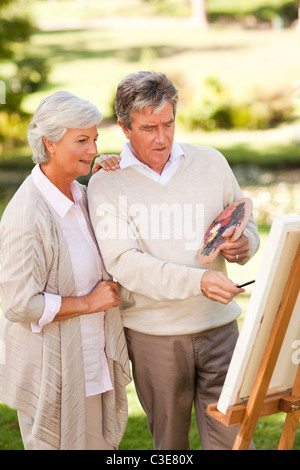 Couple de retraités peinture dans le parc Banque D'Images