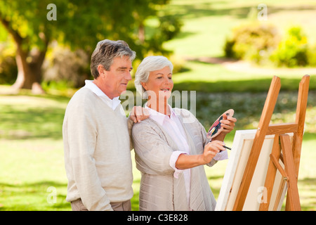 Couple de retraités peinture dans le parc Banque D'Images