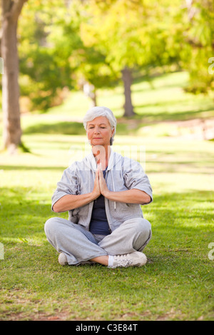 Senior woman practicing yoga in the park Banque D'Images