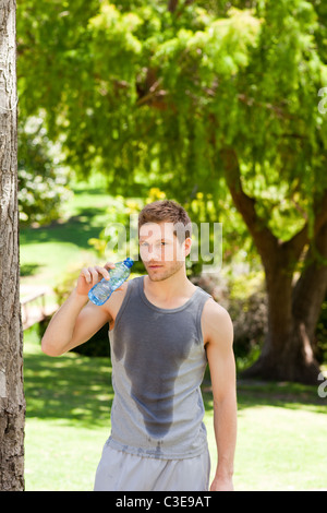 L'homme sportif dans le parc de l'eau potable Banque D'Images