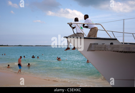 Deux guides de croisière regardent les touristes se baigner dans l'océan de Barbuda - River Landing Beach Banque D'Images