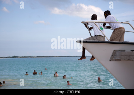 Deux guides de croisière regardent les touristes se baigner dans l'océan de Barbuda - River Landing Beach Banque D'Images