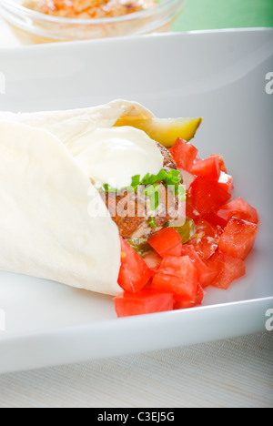 Falafel traditionnelle frais emballage sur le pain pita avec des tomates fraîches hachées Banque D'Images