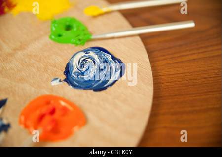 Un beau tourbillon de bleu et blanc peinture à l'huile sur une palette en bois dans un studio d'art. Banque D'Images